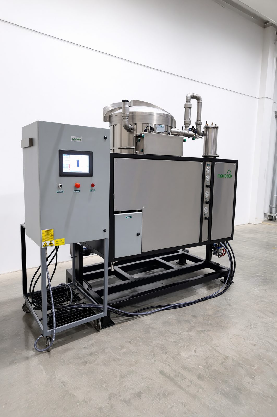 Angled view of Maratek stainless steel solvent recovery system with PLC control cabinet